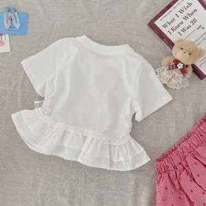 Kinderen wit t-shirt korte mouwen met volant zoom en rood geruite rok detail zicht.
