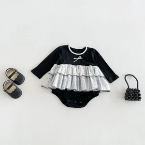 Detailed view of black baby romper with white mesh tutu, long sleeves and elegant bow detail.