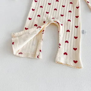 Cute infant baby cotton long sleeve romper featuring sweet red heart print and snap buttons detail.