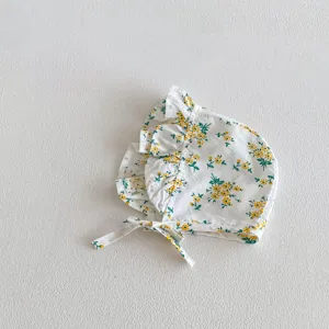 Detalle de primer plano del gorrito floral para bebé con bonitos volantes y cintas.