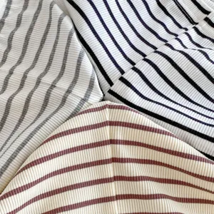 Primo piano di morbido tessuto a costine rigato e colorato per abbigliamento per bambini.