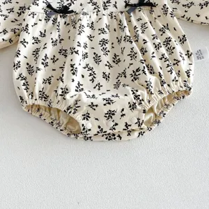 Vista detallada de un adorable pelele de algodón para bebé con estampado floral.