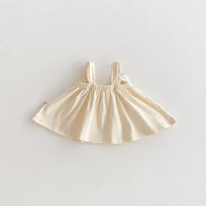 Close-up detail of soft beige baby strap top with gathered ruffle hem, thin summer style.