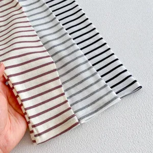 Dettaglio tessuto leggings a costine rigati per bambini, pantaloni casual morbidi primi piani