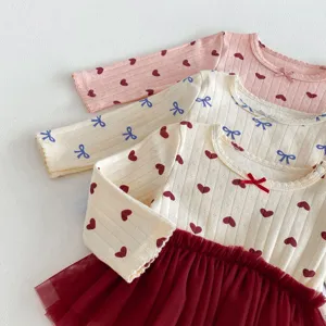 Gedetailleerd overzicht van schattige baby meisjes lange mouw romper jurk met print.