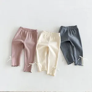 Details van schattige casual meisjesleggings met zoete kantafwerking en strikaccenten.