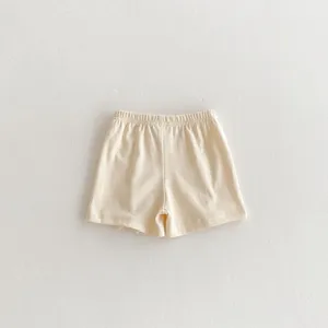 Detail shot of a baby casual shorts in light beige color, elastic waistband design, soft fabric.