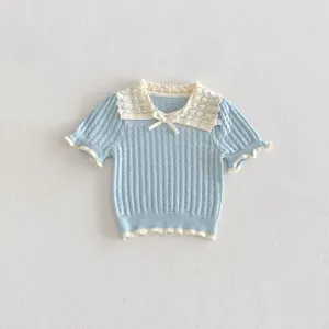 Girls blue knit top close-up, featuring cream white hollow lace collar, cute bow and ruffles.