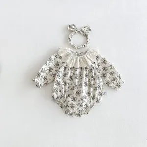 Detailaufnahme von Baby Mädchen Blumen Langarm Strampler mit süßem Spitzenkragen und Haarband.