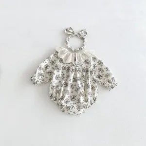Nahaufnahme Detail des Blumen-Langarm-Bodys für Babymädchen mit zartem Spitzenkragen und Haarband.
