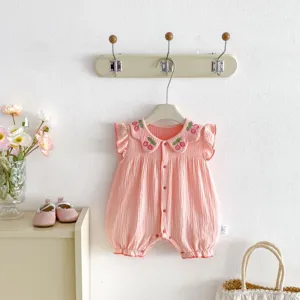 Detailed view of cute baby girl pink romper featuring sweet cherry embroidery on ruffled collar.