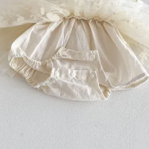 Dettaglio tutina in tulle per neonati con morbida fodera in cotone e pratici bottoni.