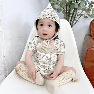 Detailed view of baby girl floral romper set with cute lace hat and matching socks for summer.