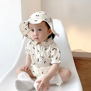 Charming baby girl summer cherry print short-sleeve romper with matching sun hat detail.