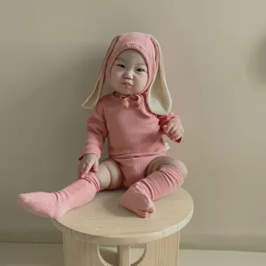 Adorable barboteuse côtelée rose à manches longues avec bonnet oreilles de lapin et chaussettes.