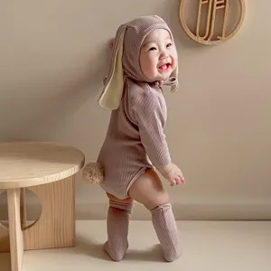 Vue détaillée d'une barboteuse à oreilles de lapin en tricot côtelé avec une douce queue duveteuse.