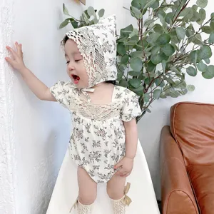 Detail view of cute baby girl floral romper set with matching bonnet and socks, summer wear.
