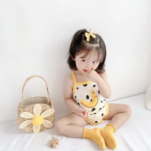 Cute baby cotton romper detail showing soft fabric, yellow straps and playful banana print.