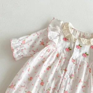 Vue détaillée de la barboteuse bébé en coton à manches longues avec imprimé floral rose.