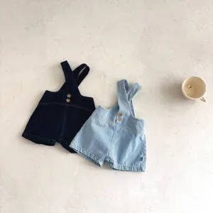 Vista dettagliata di salopette in denim per neonati blu scuro e chiaro con bottoni.