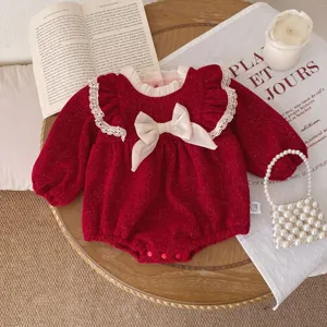 Red baby romper detail with white lace ruffles, sweet bow accent, and soft fleece lining fabric.