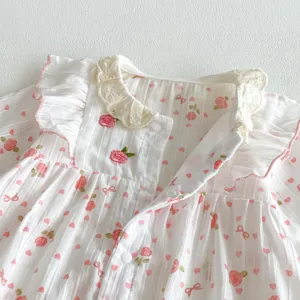 Détail de barboteuse florale pour bébé fille, coton doux avec col en dentelle et volants.