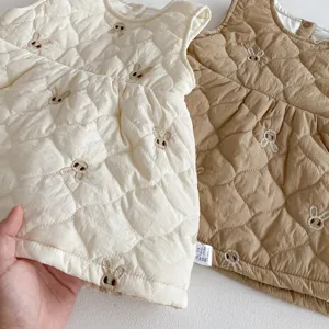 Vista dettagliata del gilet trapuntato per bambini con ricamo di coniglietti, morbido inverno.