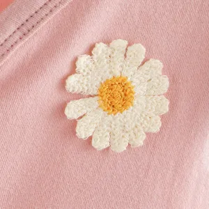 Detalle de mameluco de algodón para niña con bonito diseño de margarita bordada.