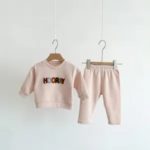 Dettaglio set top e pantaloni manica lunga in tessuto waffle rosa, abbigliamento bimbo.