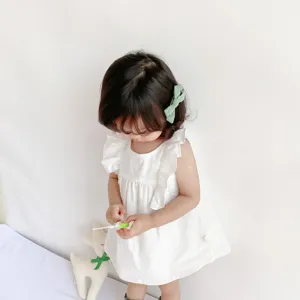 Dettaglio abito bianco volant per bambina, primo piano grazioso vestito principessa senza maniche.