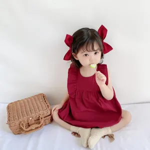 Dettaglio tutina senza maniche per bambina, vestito estivo rosso con volant primo piano.