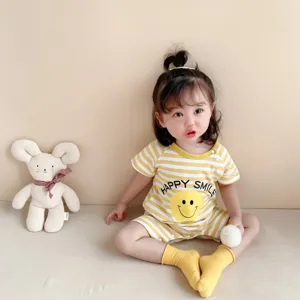 Detailed view of a cute baby summer romper, soft pure cotton, yellow stripes, smiley face.