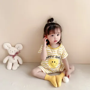 Detailed close-up view of infant cotton romper in yellow stripe with cute smiley face print.