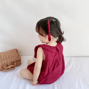 Dettaglio tutina cotone estate bambina, design grazioso maniche a volant in rosso.