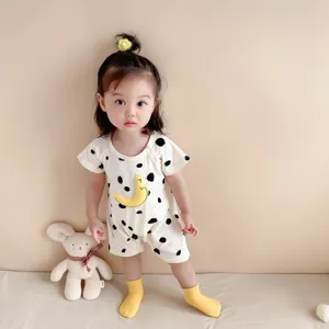 Cute baby romper detail shot featuring soft cotton fabric, playful print, and matching yellow socks.