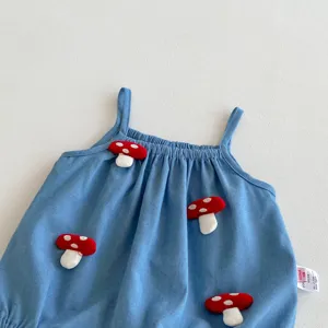 Primer plano detallado del lindo pelele para bebé niña con aplicaciones de hongos rojos 3D.