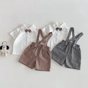 Detailed view of baby boy summer short sleeve shirt and plaid suspenders shorts set.