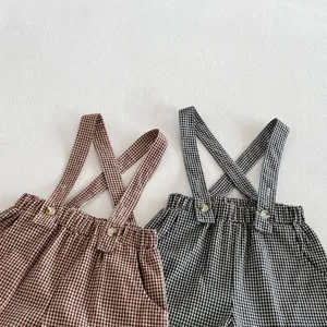 Toddler gingham overalls detail shot featuring classic crisscross straps and cute decorative buttons.