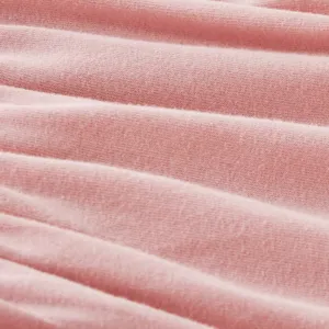 Primer plano detallado de tela de algodón rosa suave para ropa de verano cómoda para bebés.