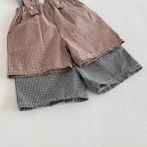 Close-up detail of toddler boys plaid overall shorts, comfortable checkered summer baby clothing.