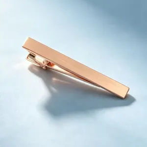 Détail élégant de pince à cravate en or rose, finition métallique lisse pour costume homme.