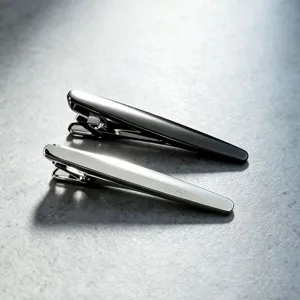 Vue détaillée de pinces à cravate métalliques élégantes et lisses en canon de fusil et argent.