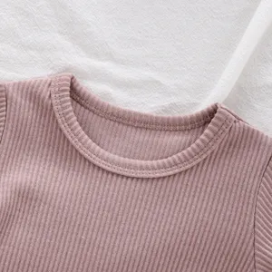 Détail de body bébé à manches longues en tricot côtelé, haut basique doux pour nourrisson rose.