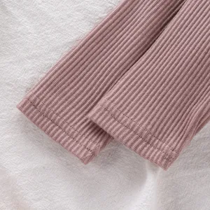 Gros plan détail du poignet à manches longues côtelé rose doux pour vêtement de bébé