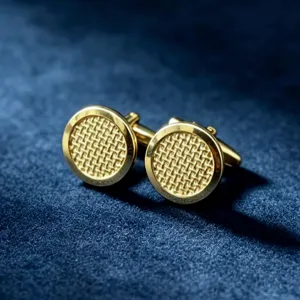 Gouden metalen manchetknoppen met een fijn ruitpatroon, gedetailleerde close-up.
