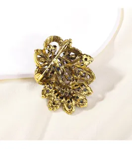 Vintage gold tone crystal rhinestone brooch pin back detail shot, elegant fashion jewelry accessory.