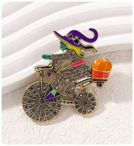 Exquisite Halloween witch on bicycle brooch detail, rhinestone and enamel alloy pin for festive style.