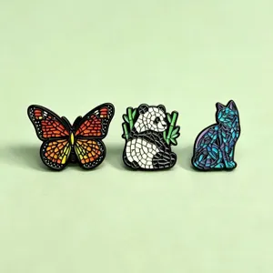 Detail van emaille broches met unieke diermotieven in mozaïekstijl, vlinder, panda en kat.
