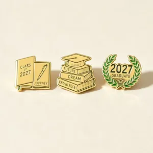 Set di 3 spille di laurea in metallo smaltato dorato con tema 2027, berretto e design a corona.