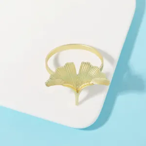 Primer plano del servilletero de metal con hoja de ginkgo dorada que muestra textura y finos detalles.